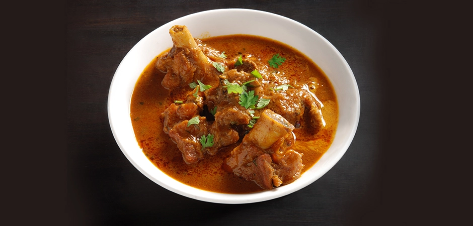 Spicy Indian mutton curry with bones and cilantro, a true taste of the best Indian food experience.